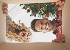 man and woman looking into a christmas gift box